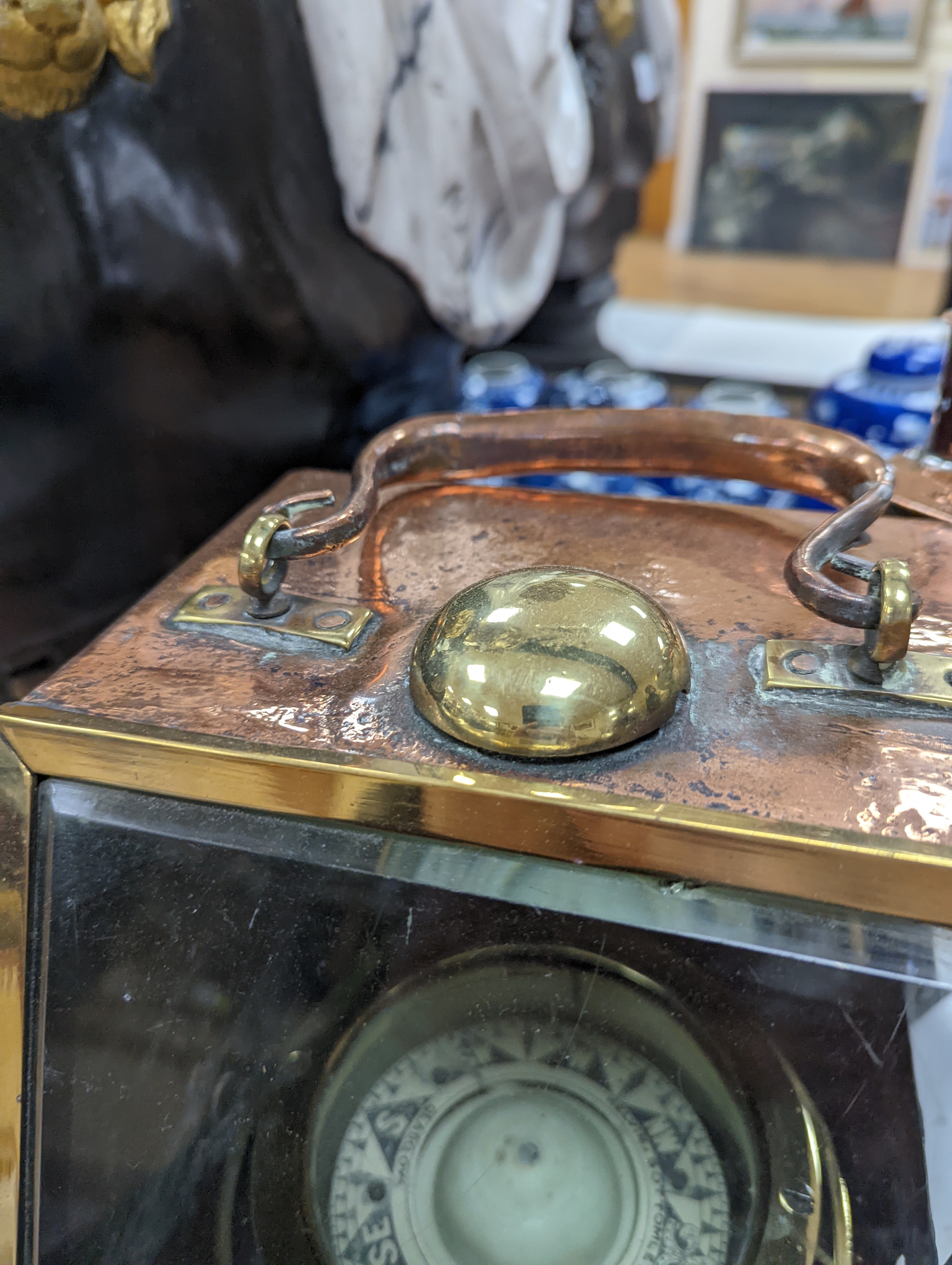 A copper ship's binnacle compass, a brass oil lamp, a brass jug and a copper kettle